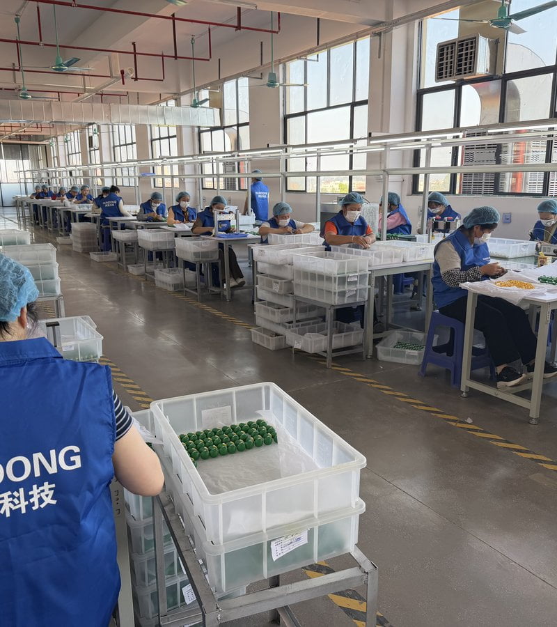 Workers painting and assembling figures on the Rundong workshop floor